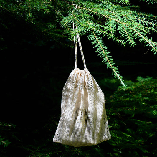 Brew & Blossom mini tea flight drawstring bag hanging from an evergreen branch