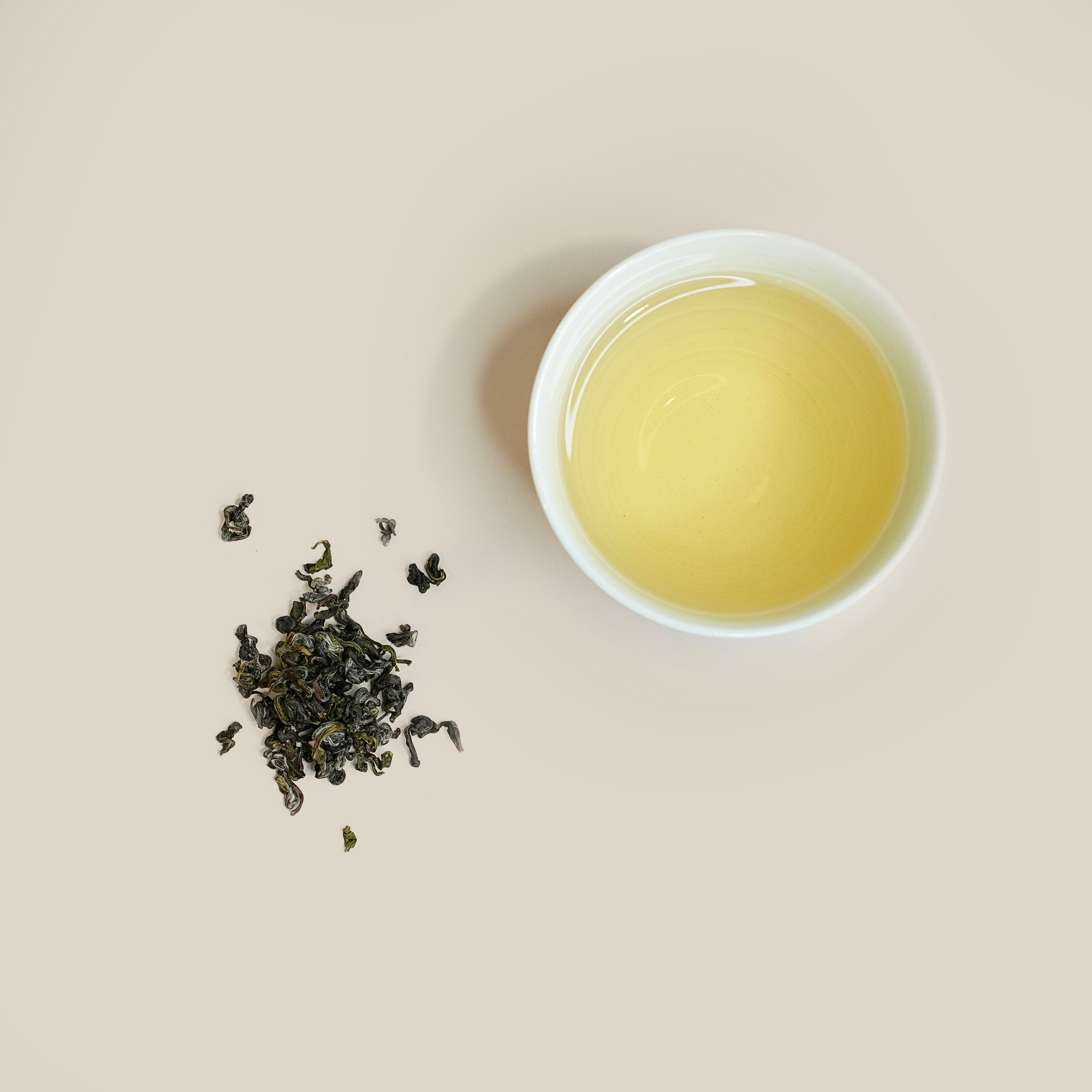 Yellow Pearl Tea dry tea leaves with brewed tea liquor in cup